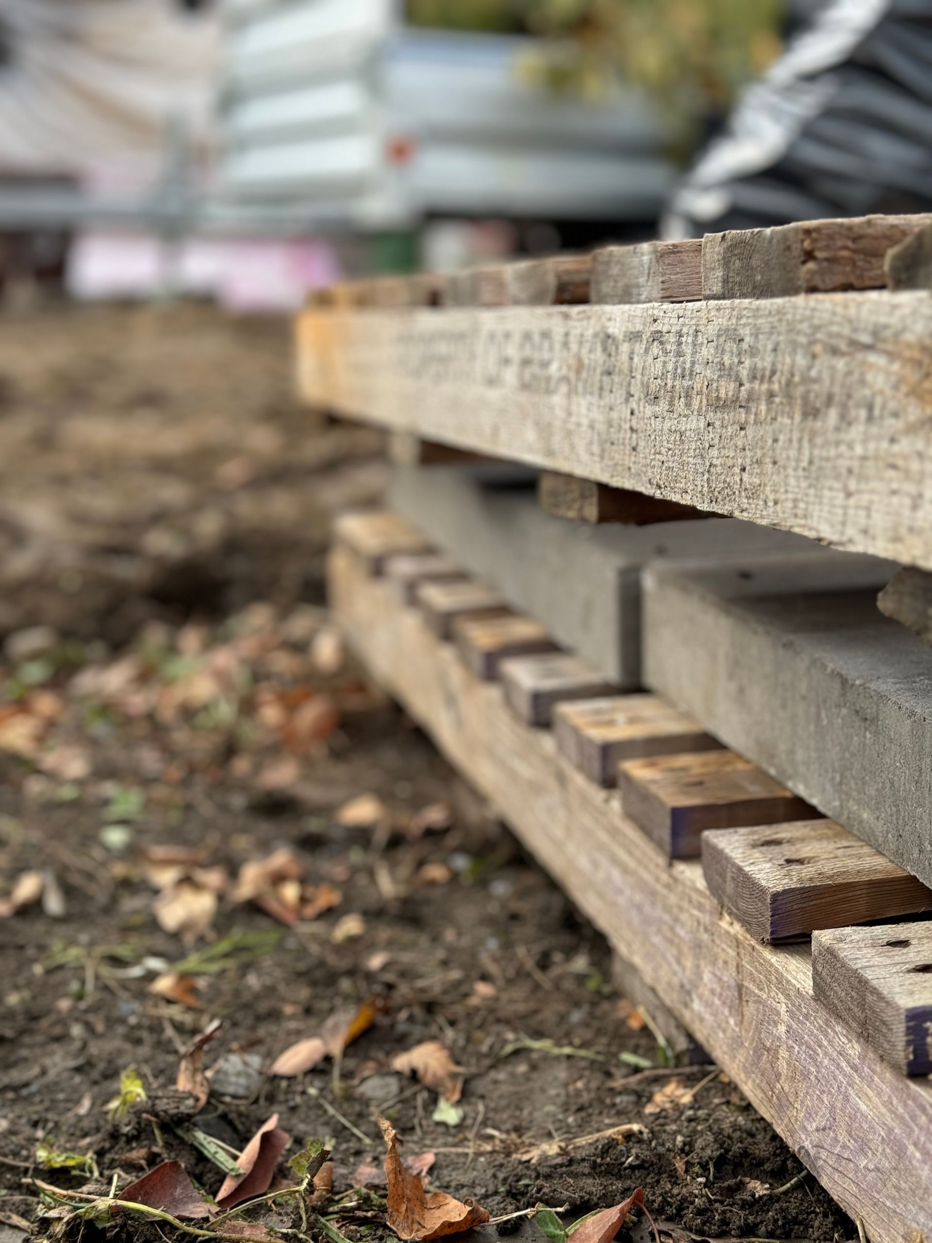 Une pile de palettes en bois posées les unes sur les autres sur le sol.
