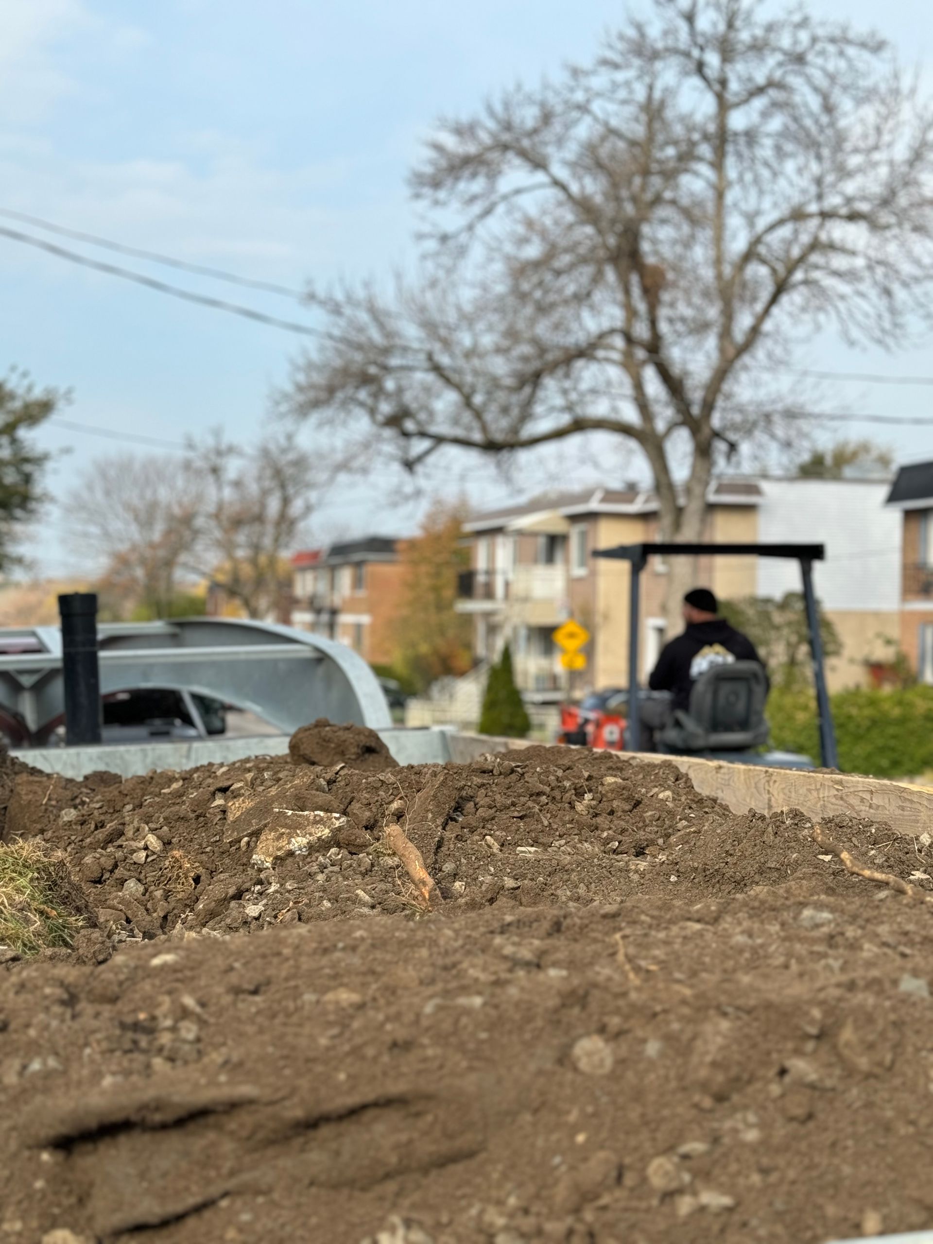 Un homme conduit un bulldozer sur un chemin de terre