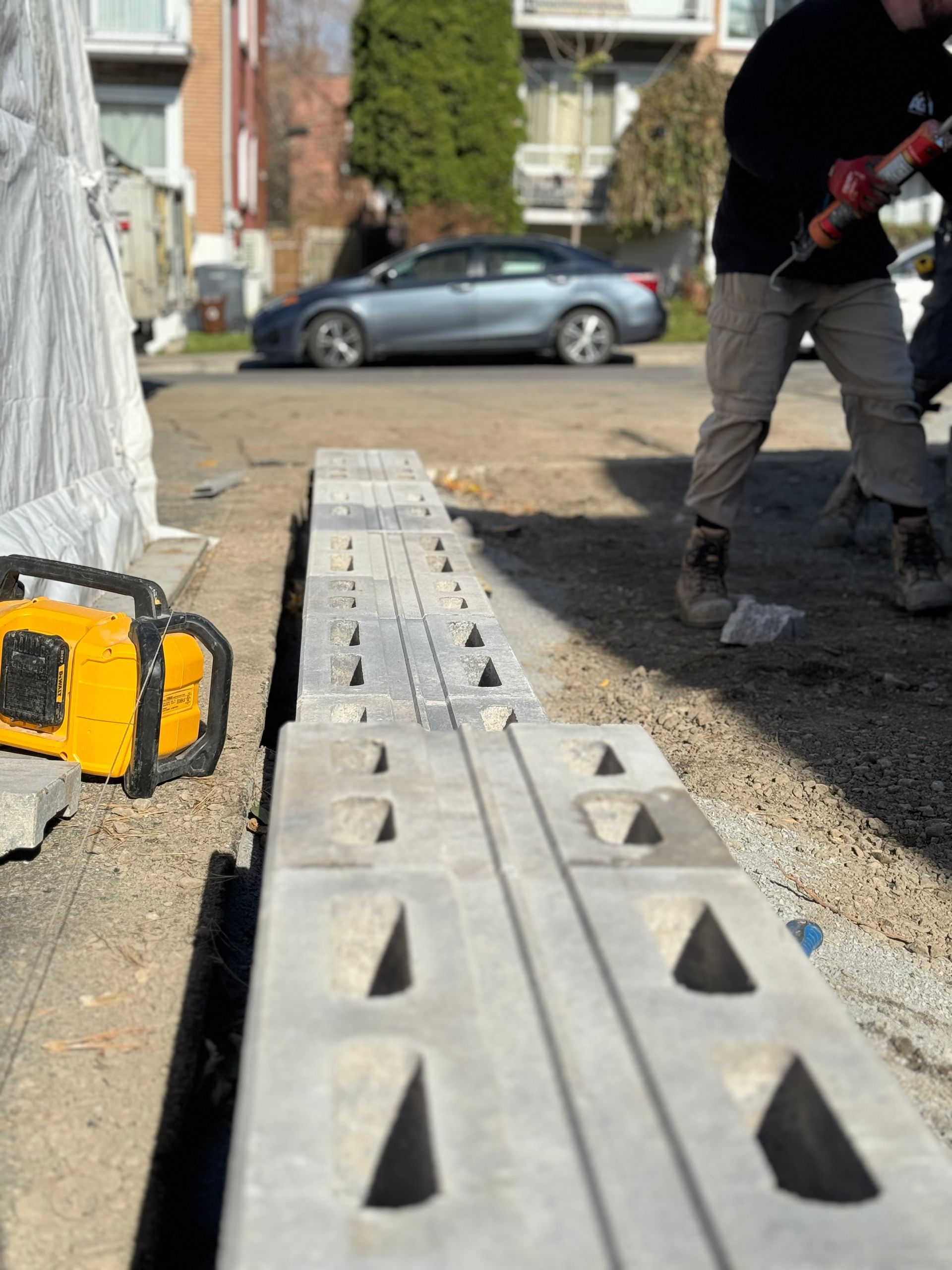 Un homme utilise une perceuse pour percer des trous dans des blocs de béton.