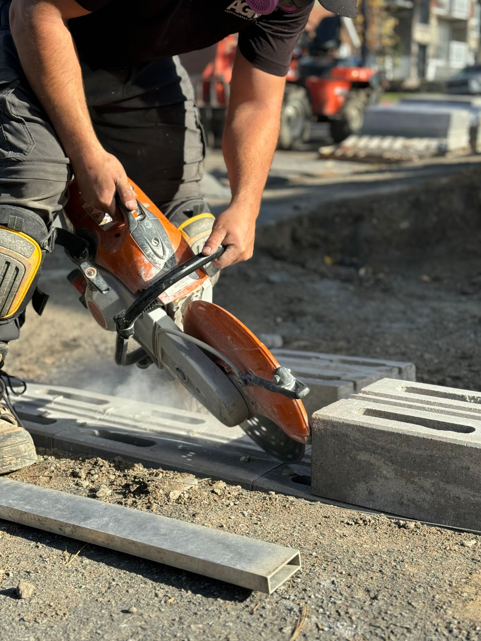 Un homme coupe un morceau de béton avec une scie circulaire.