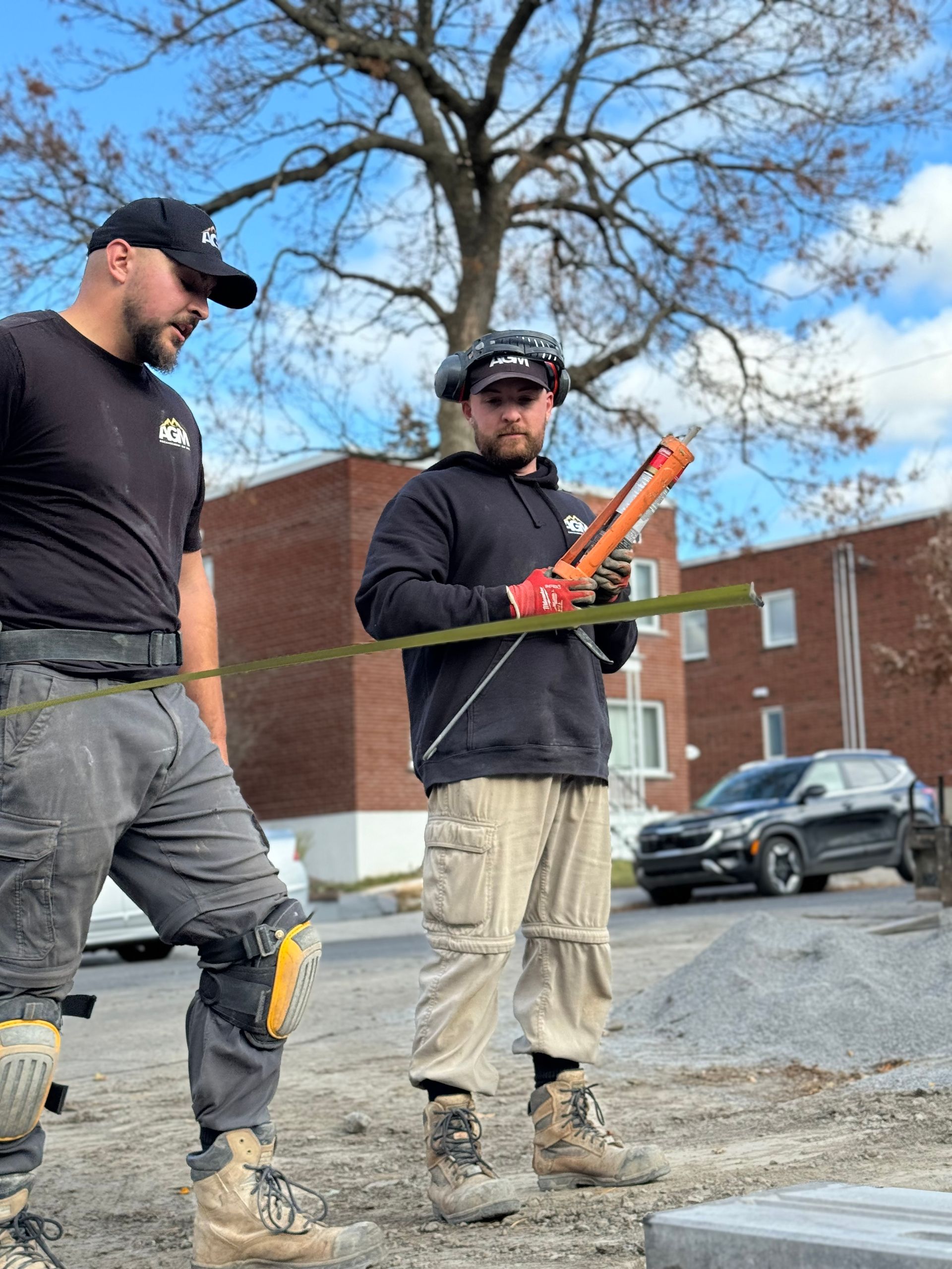Deux hommes se tiennent côte à côte sur un chantier de construction.