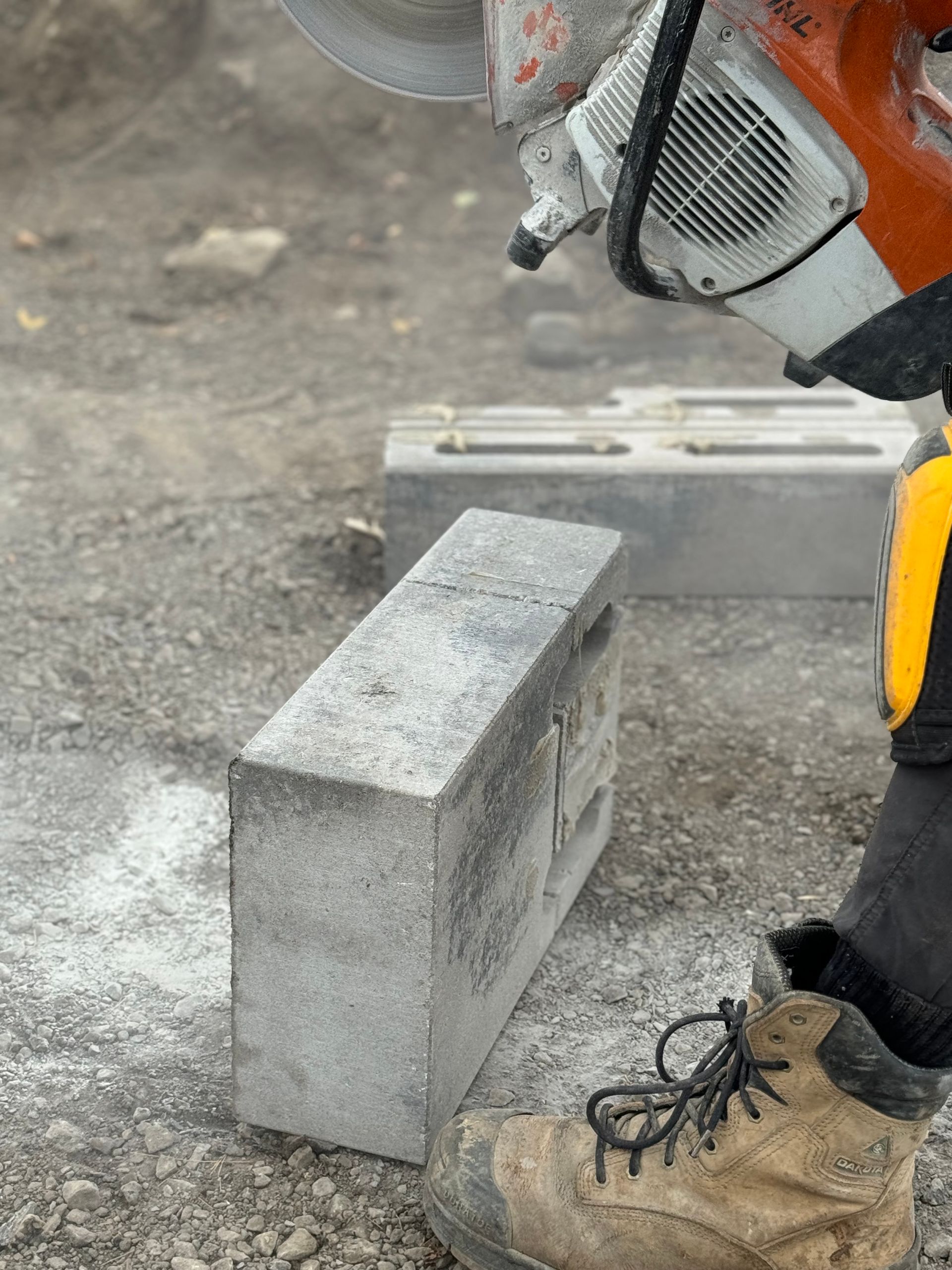 Une personne coupe une brique avec une tronçonneuse.