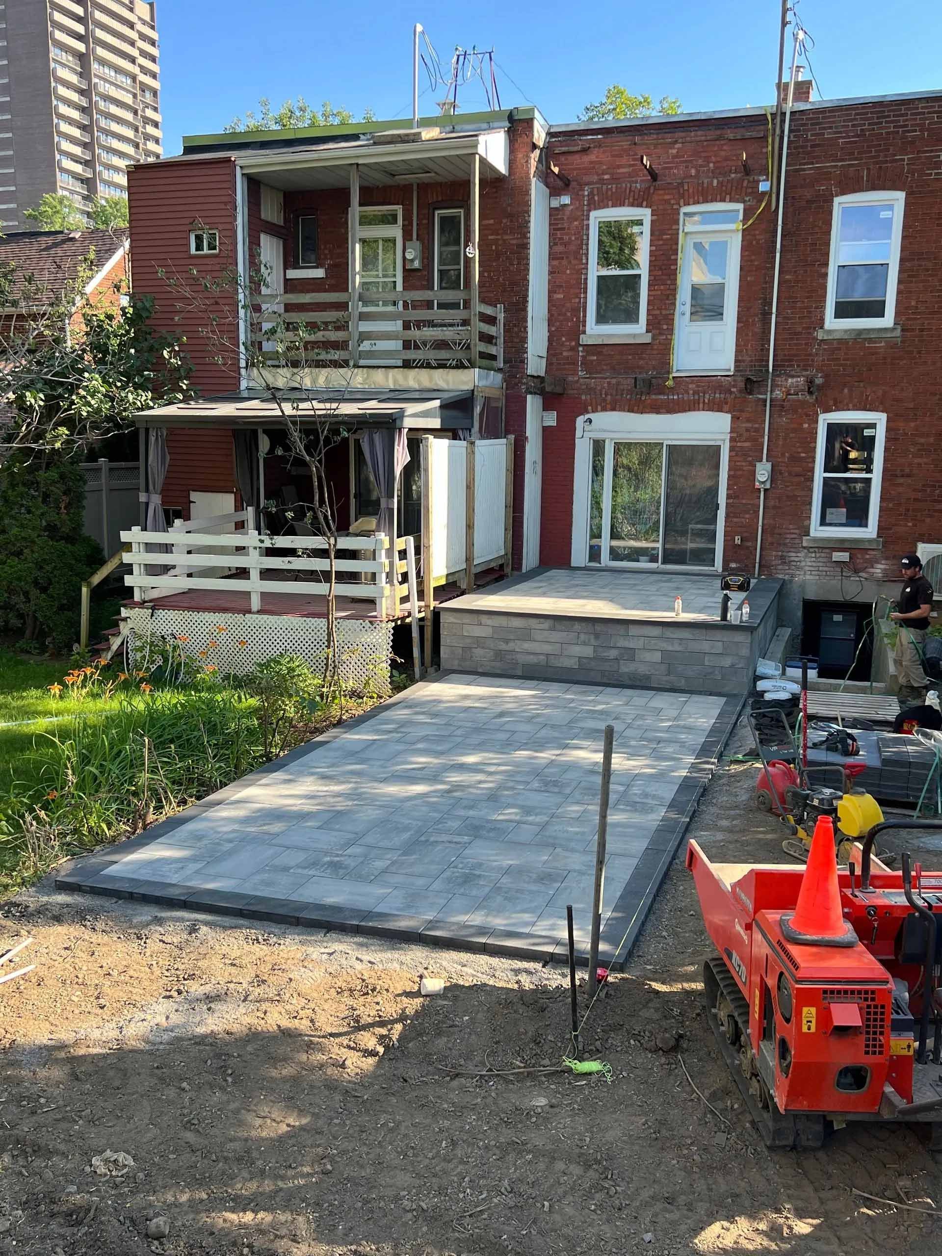 Un bâtiment en briques avec un patio en construction devant lui.