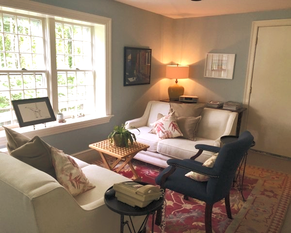 A living room with a couch and two chairs