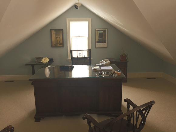 An attic office with a desk and a chair