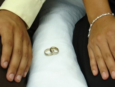 A pair of wedding rings on a white pillow