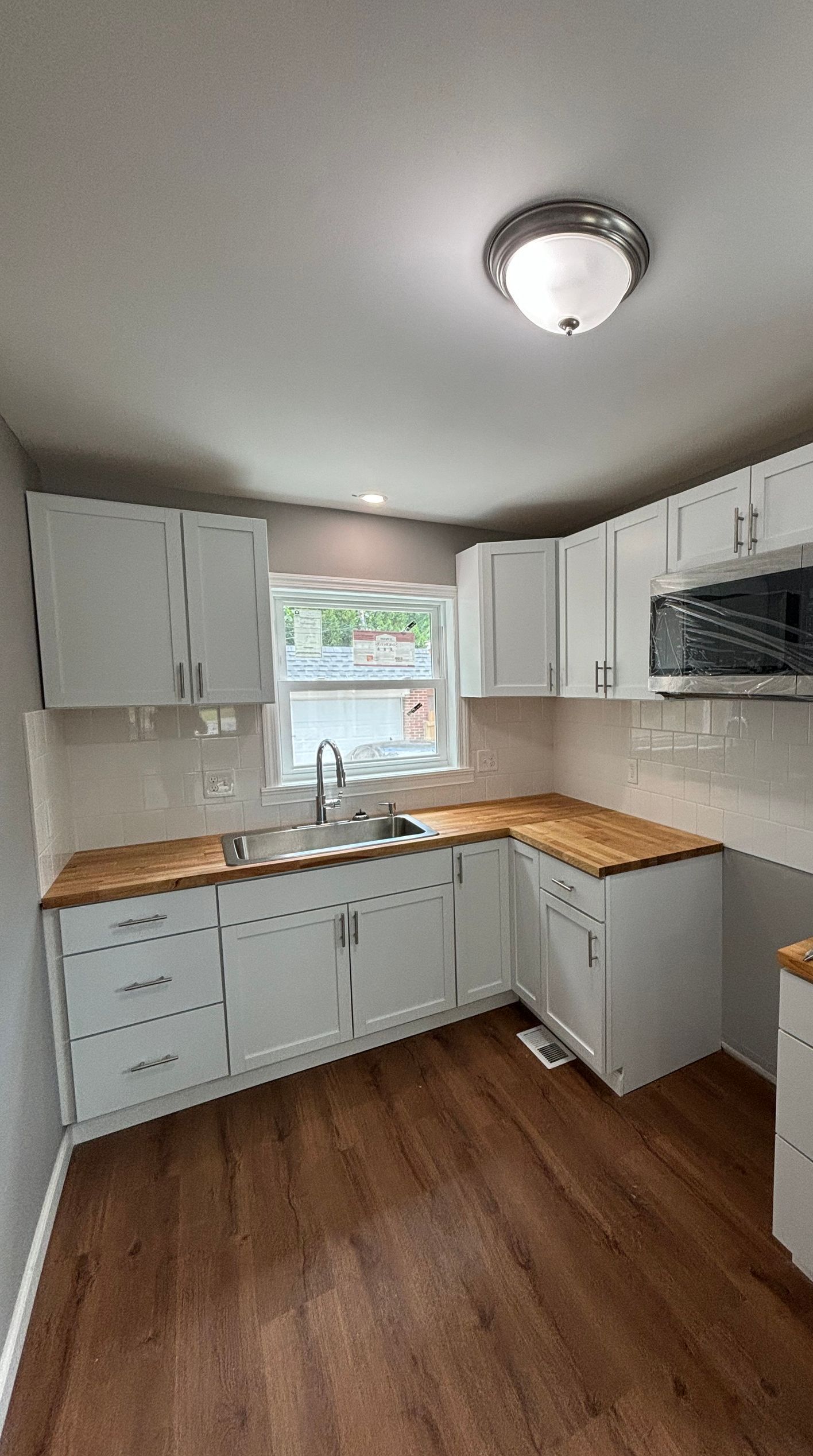 A kitchen with white cabinets and a stove top oven.