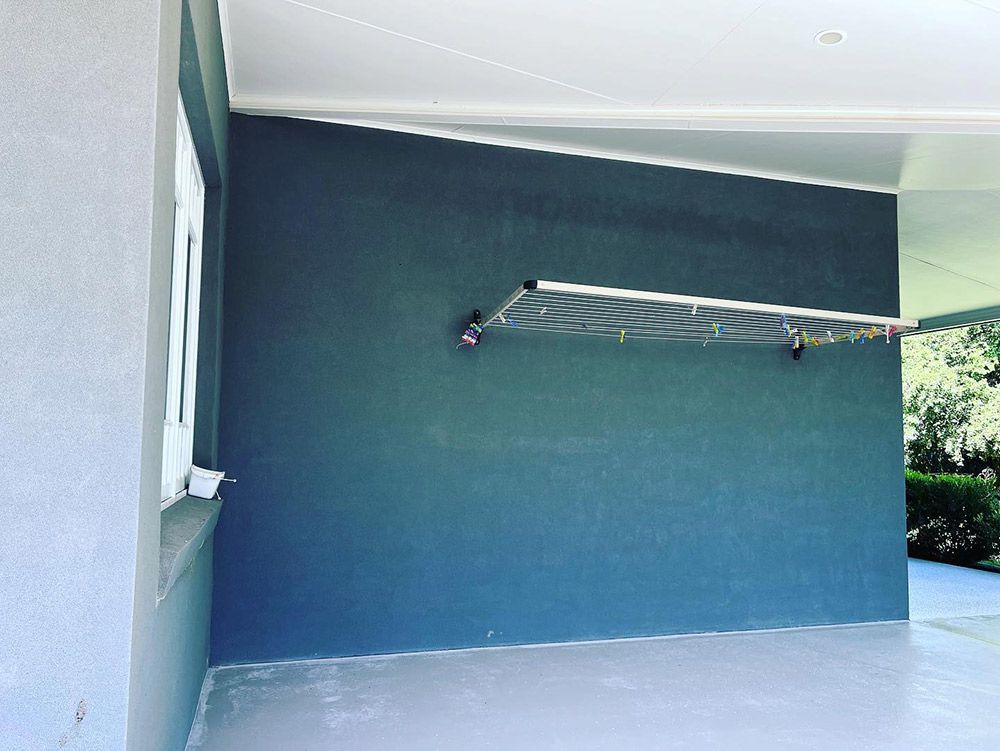 A Clothes Line is Hanging on the Side of a Building — S & S Tiling and Rendering in Walgett, NSW