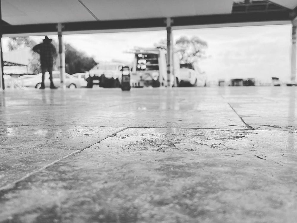 Black and White Photo of Concrete Floor With Person in Background — S & S Tiling and Rendering in Geurie, NSW