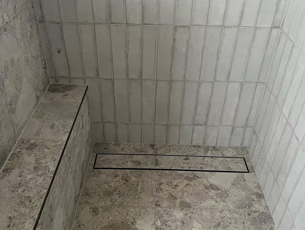 A Bathroom With a Walk in Shower and a Drain — S & S Tiling and Rendering in Cobar, NSW