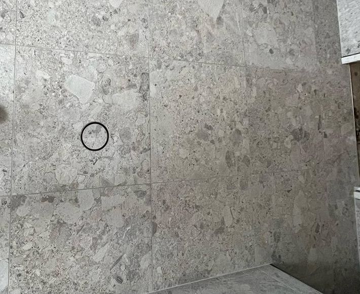 A Person is Standing on a Tiled Floor With a Circle in the Middle — S & S Tiling and Rendering in Geurie, NSW