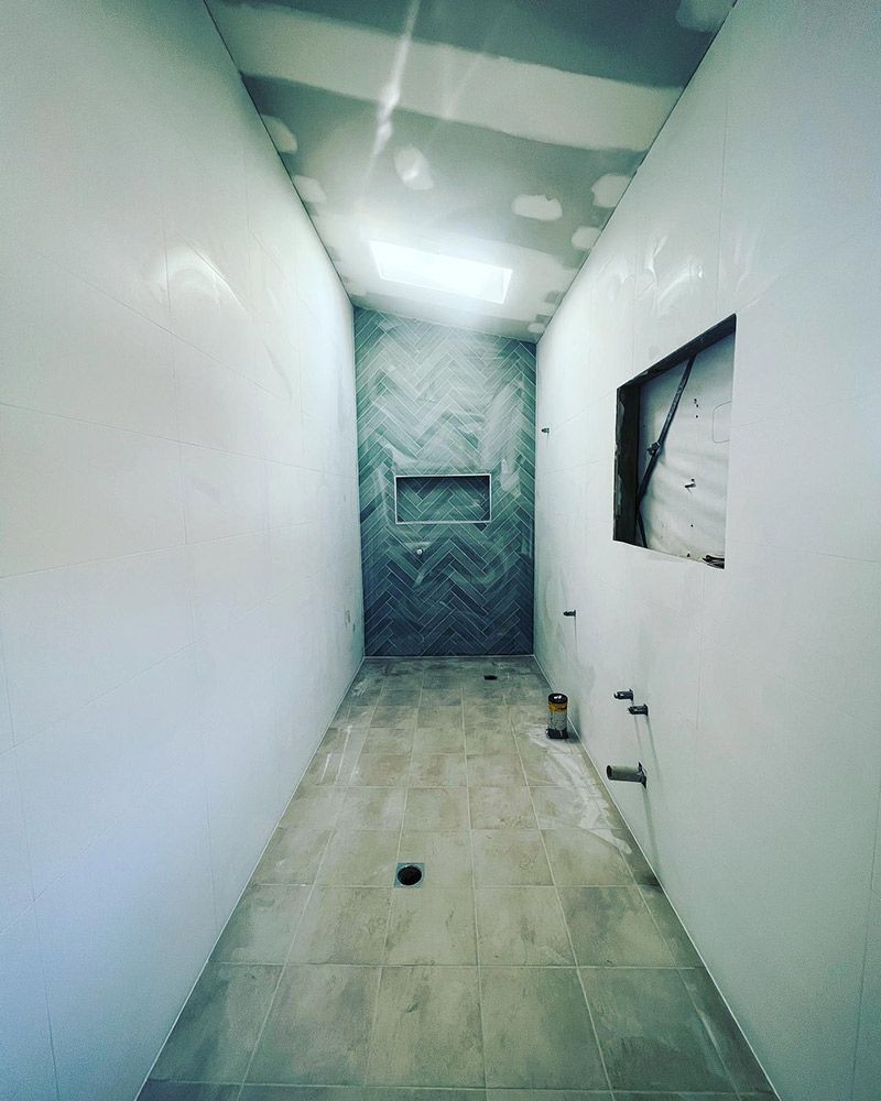 A Long Narrow Room With a Chevron Pattern on the Wall — S & S Tiling and Rendering in Orange, NSW