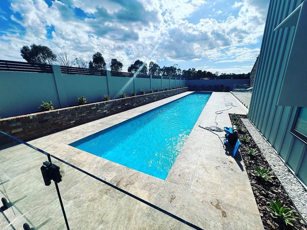 There is a Large Swimming Pool in the Backyard of a House — S & S Tiling and Rendering in Coonamble, NSW