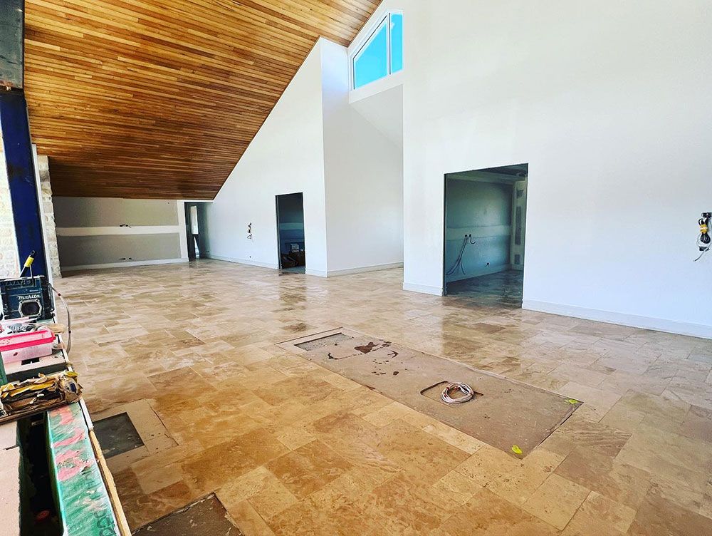A Large Empty Room With a Tiled Floor and a Wooden Ceiling — S & S Tiling and Rendering in Bathurst, NSW