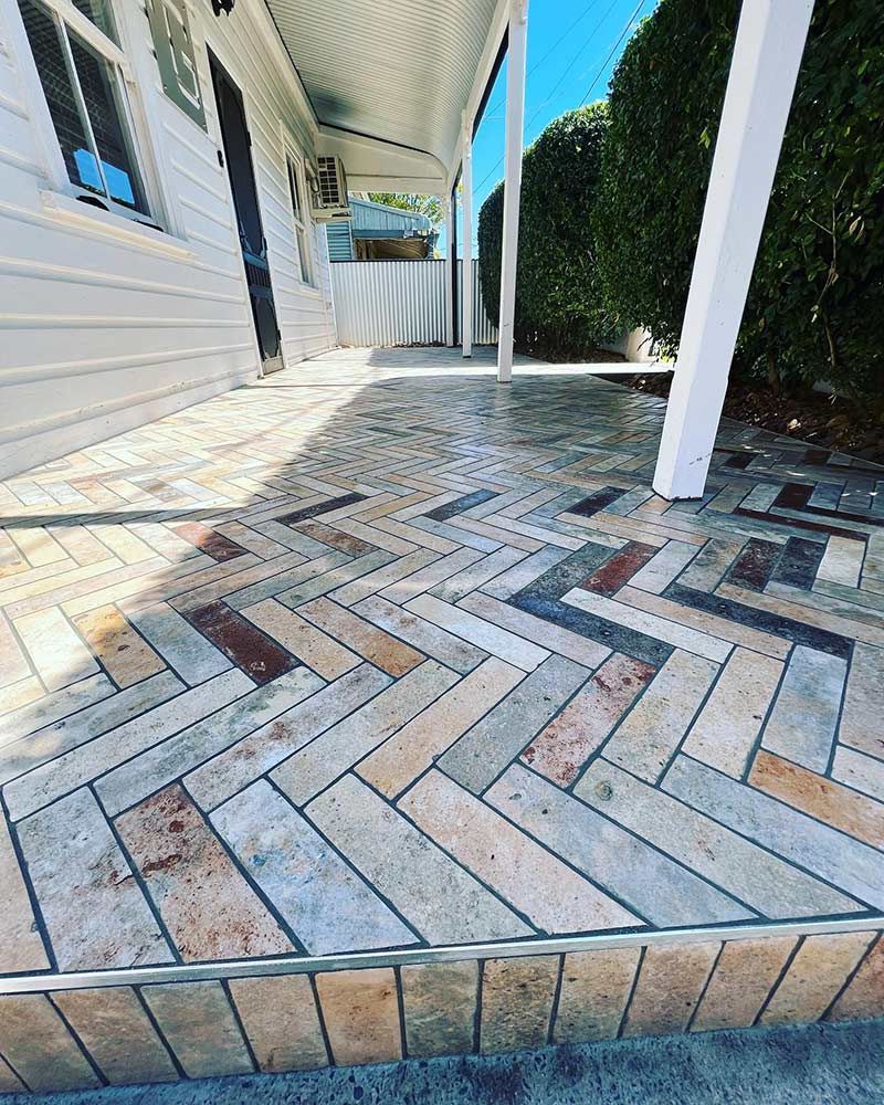 A Brick Walkway With a Herringbone Pattern in Front of a House — S & S Tiling and Rendering in Geurie, NSW
