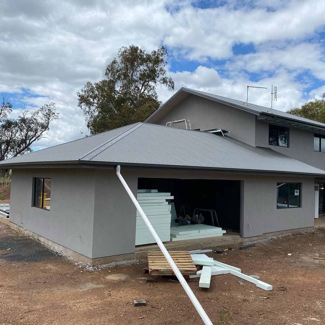 A Large House With a Gray Roof is Being Built — S & S Tiling and Rendering in Orange, NSW