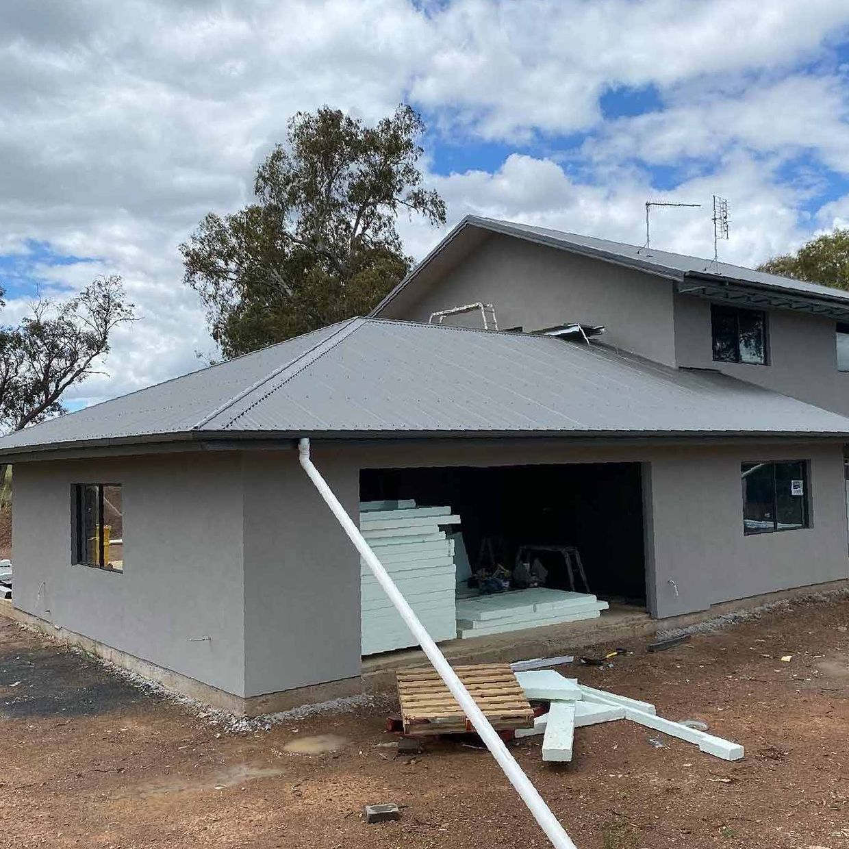 A Large House With a Gray Roof is Being Built — S & S Tiling and Rendering in Parkes, NSW