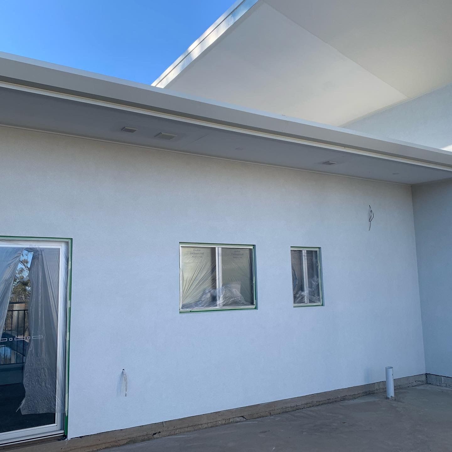 A White Building With Three Windows and a Sliding Glass Door — S & S Tiling and Rendering in Bathurst, NSW
