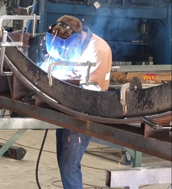 A field of wheat with the sun setting in the background.