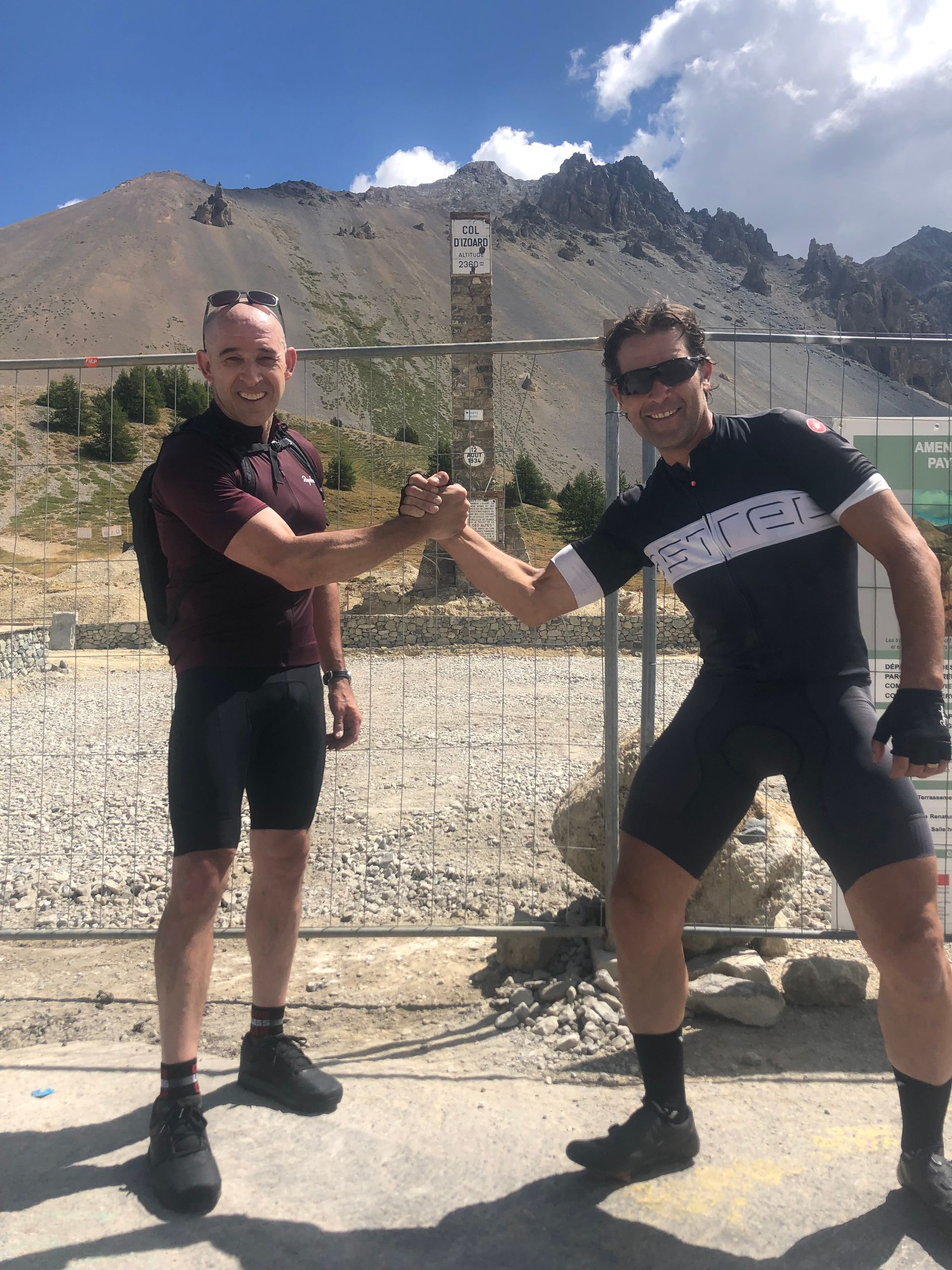 Two men giving each other a high five in front of a mountain