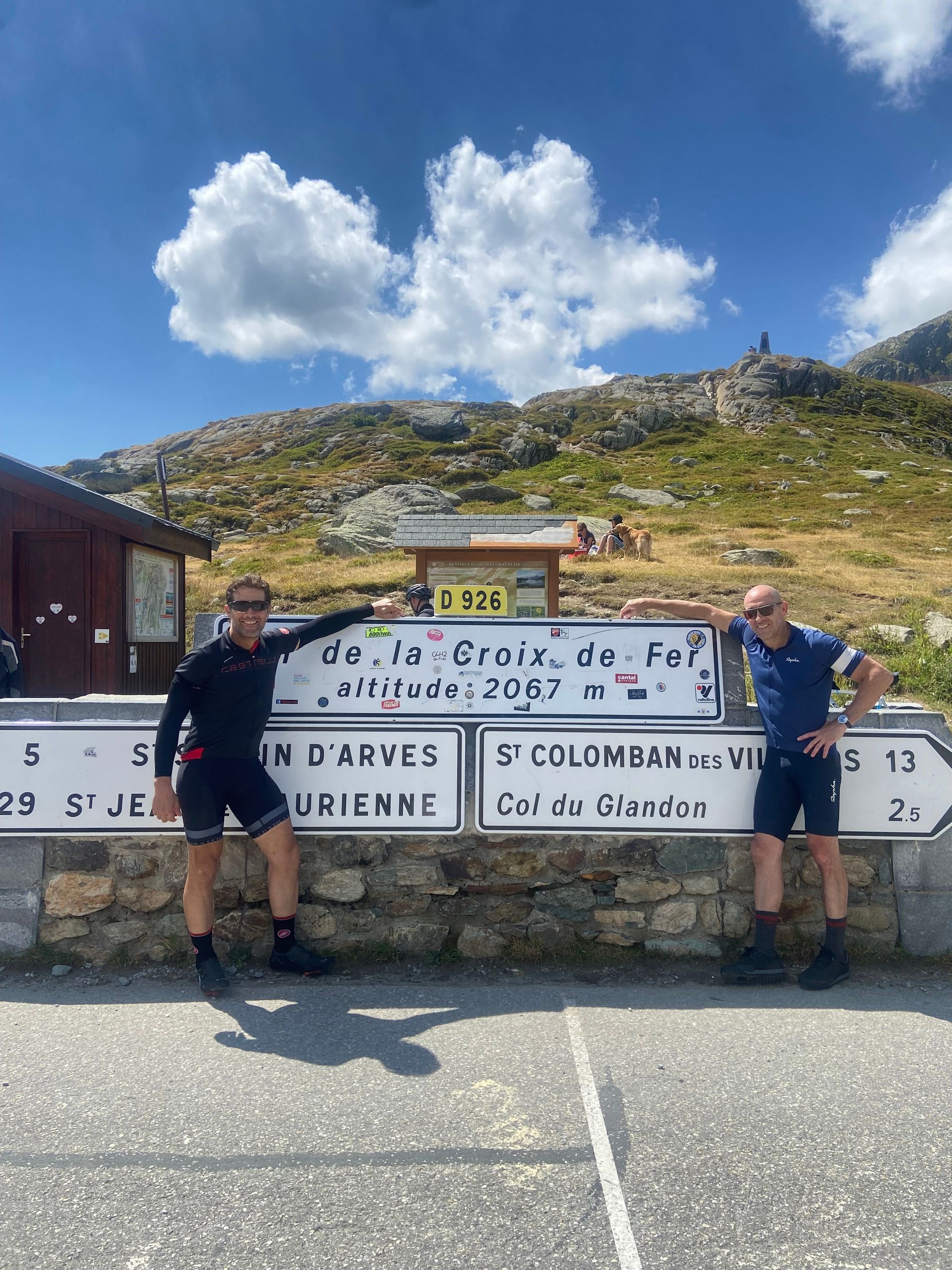 Two men standing in front of a sign that says colombam
