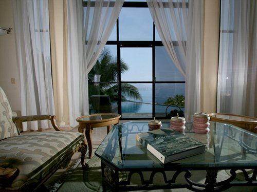 A living room with a glass table and a book on it