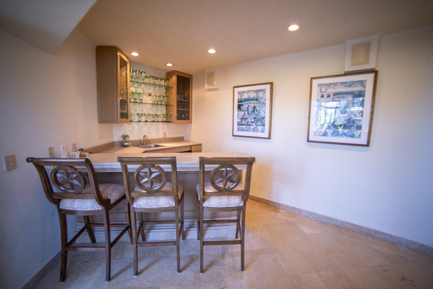 A room with a bar and chairs in it.