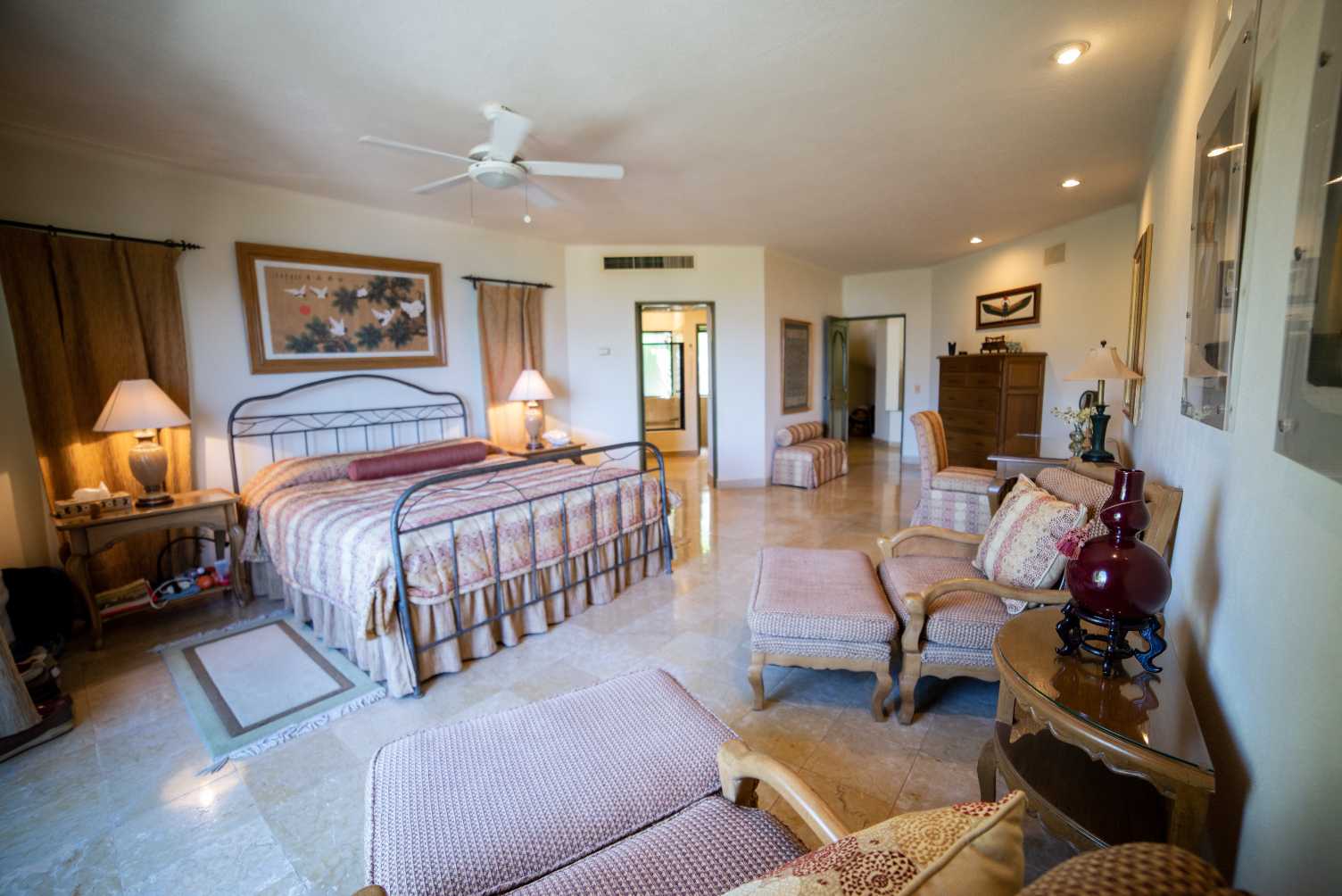 A large bedroom with a king size bed and a ceiling fan.