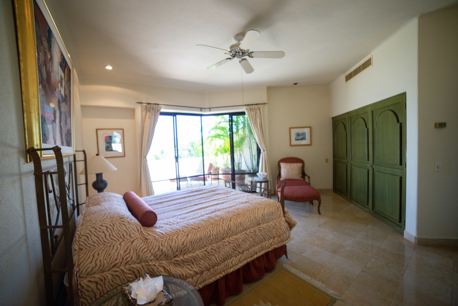 a bedroom with a large bed and a ceiling fan
