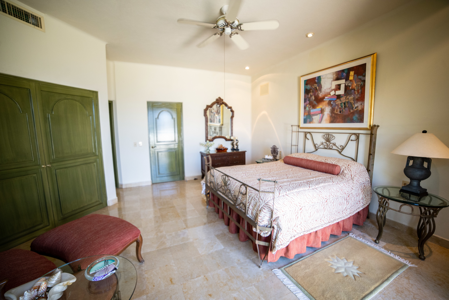 a bedroom with a large bed and a ceiling fan