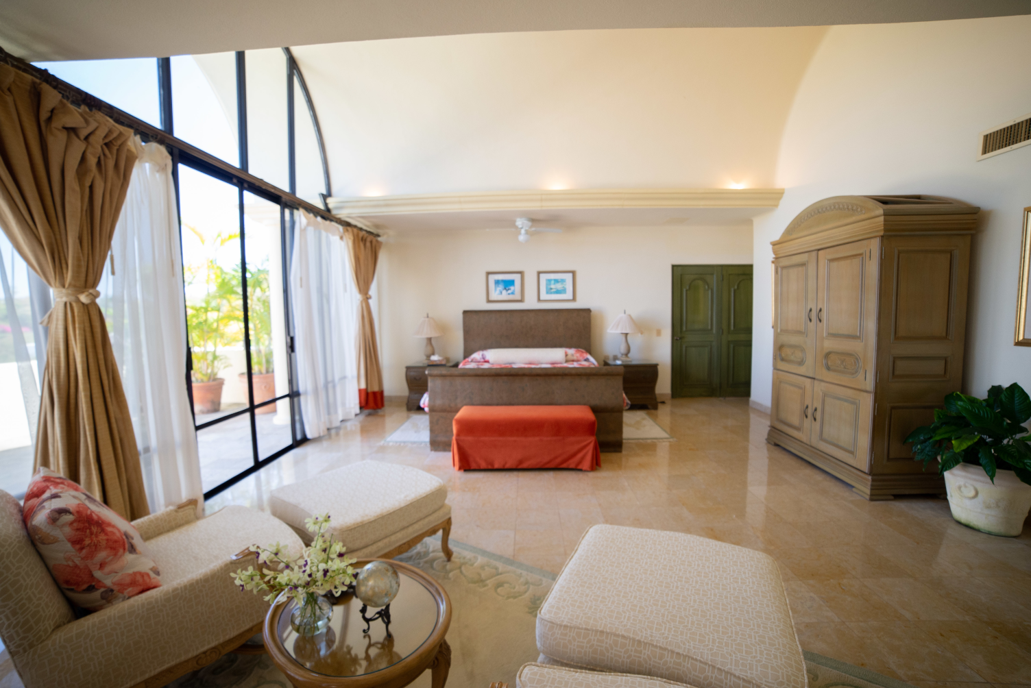 A bedroom with a large bed and a lot of windows