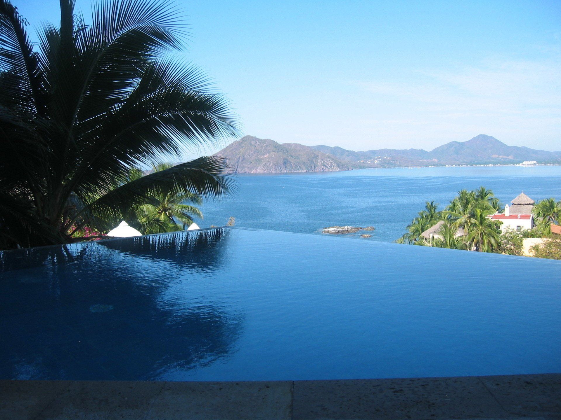 a swimming pool with a view of the ocean and mountains