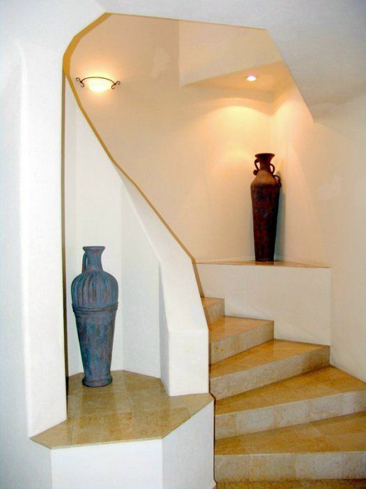 A curved staircase with a vase in the corner