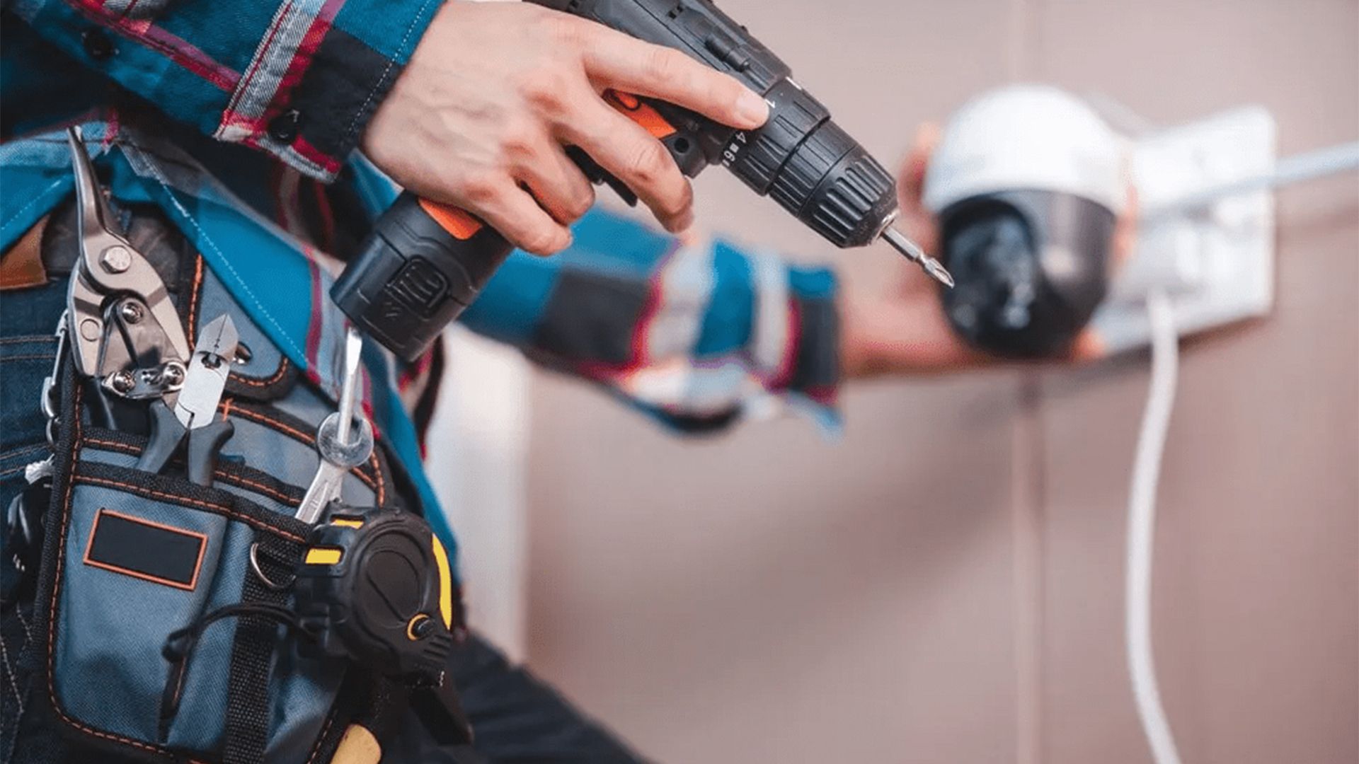 A Man is Installing a Security Camera With a Drill — T.N. Locke Communications In Ingham, QLD