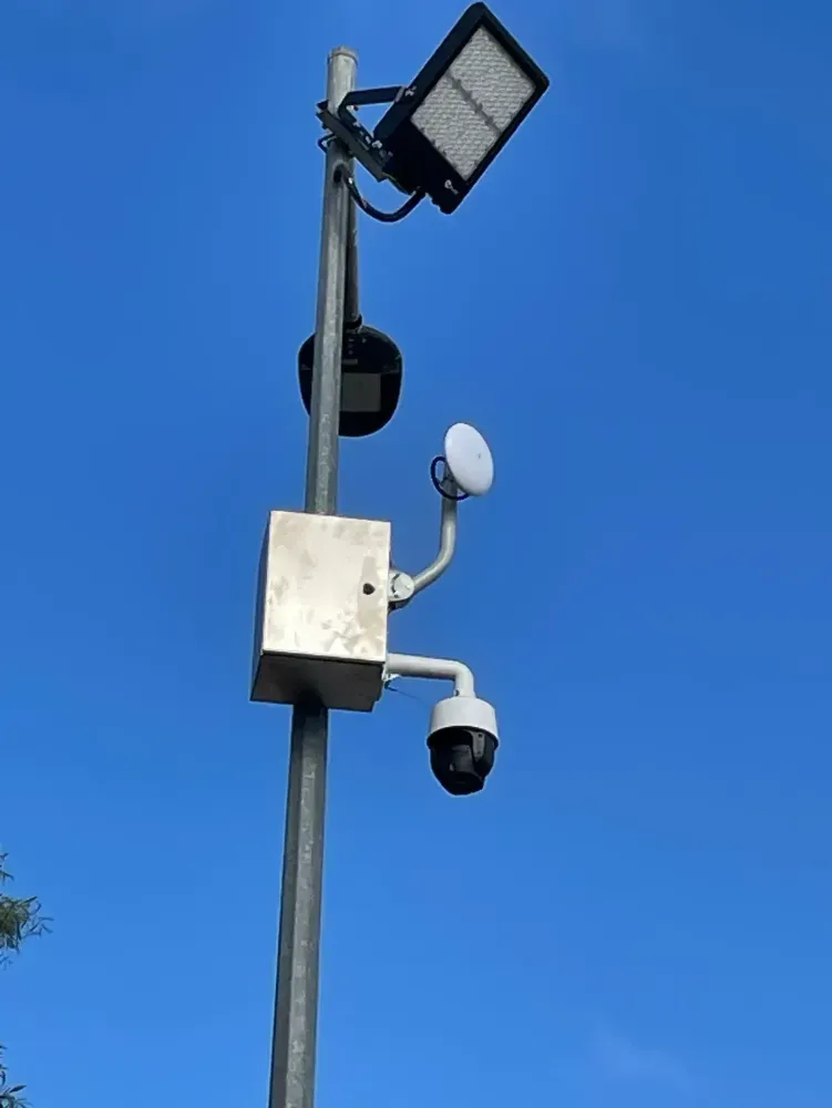 A Street Light with A Camera Attached to It Against a Blue Sky — T.N. Locke Communications In Kirwan, QLD