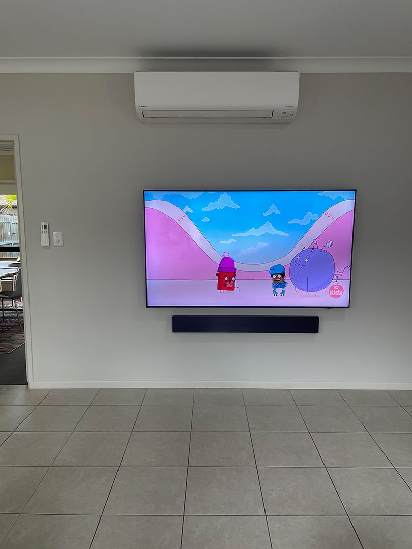 A Large Flat Screen Tv Is Hanging on A Wall in A Living Room — T.N. Locke Communications In Kirwan, QLD