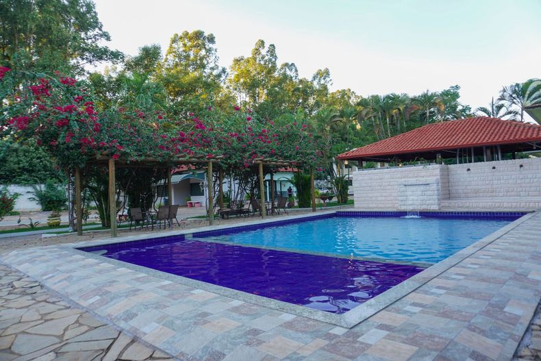 Uma grande piscina com telhas roxas e telhado vermelho