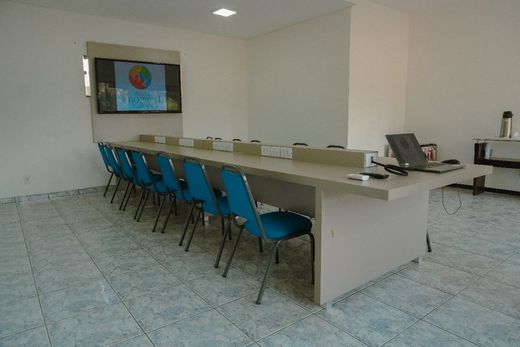 Uma sala de conferências com uma mesa longa e cadeiras azuis