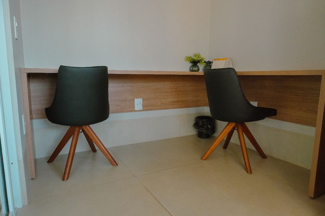 Duas cadeiras estão sentadas em uma mesa em uma sala.