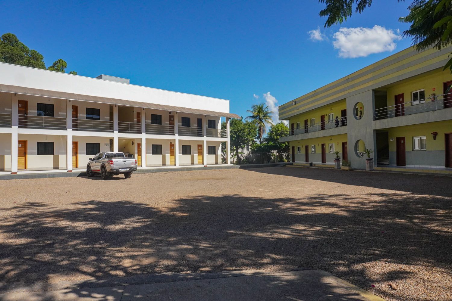 Um caminhão branco está estacionado em frente a um grande prédio.