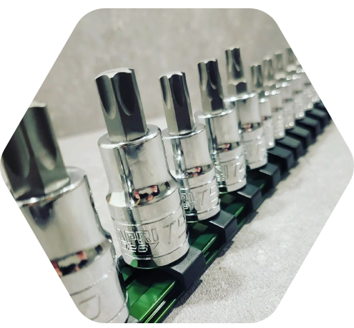 A row of chrome sockets are lined up on a green tray