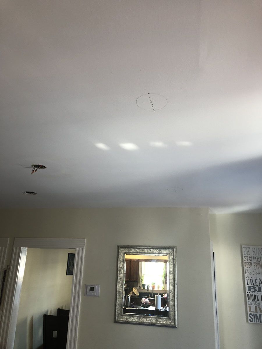 Ceiling with a light fixture, mirror, and light fixtures.