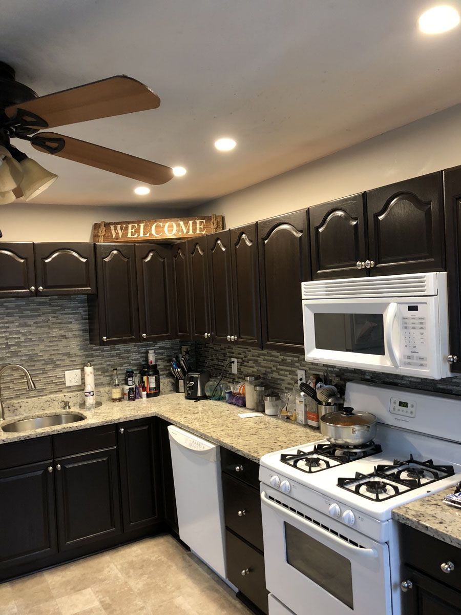 Dark brown kitchen cabinets, white appliances, and granite countertops. A 