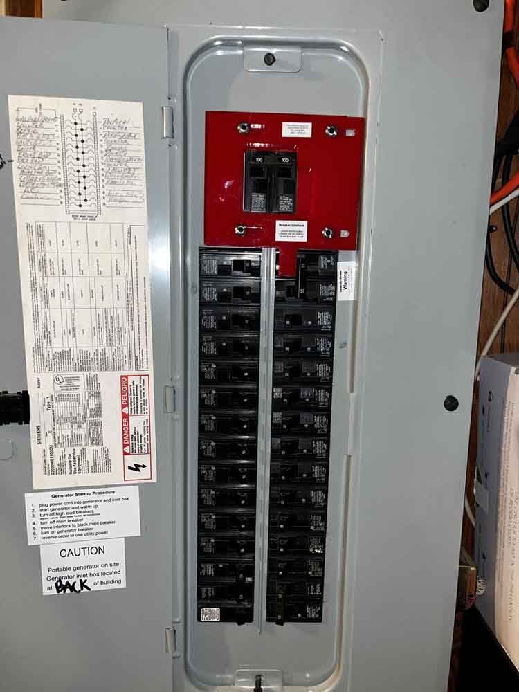 Electrical panel with breakers and red main breaker.