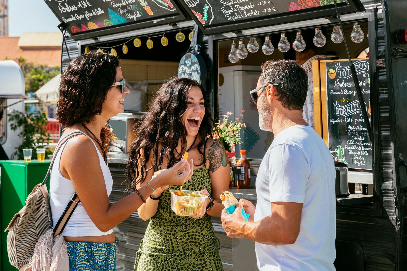 A group of people are standing in front of a food truck.