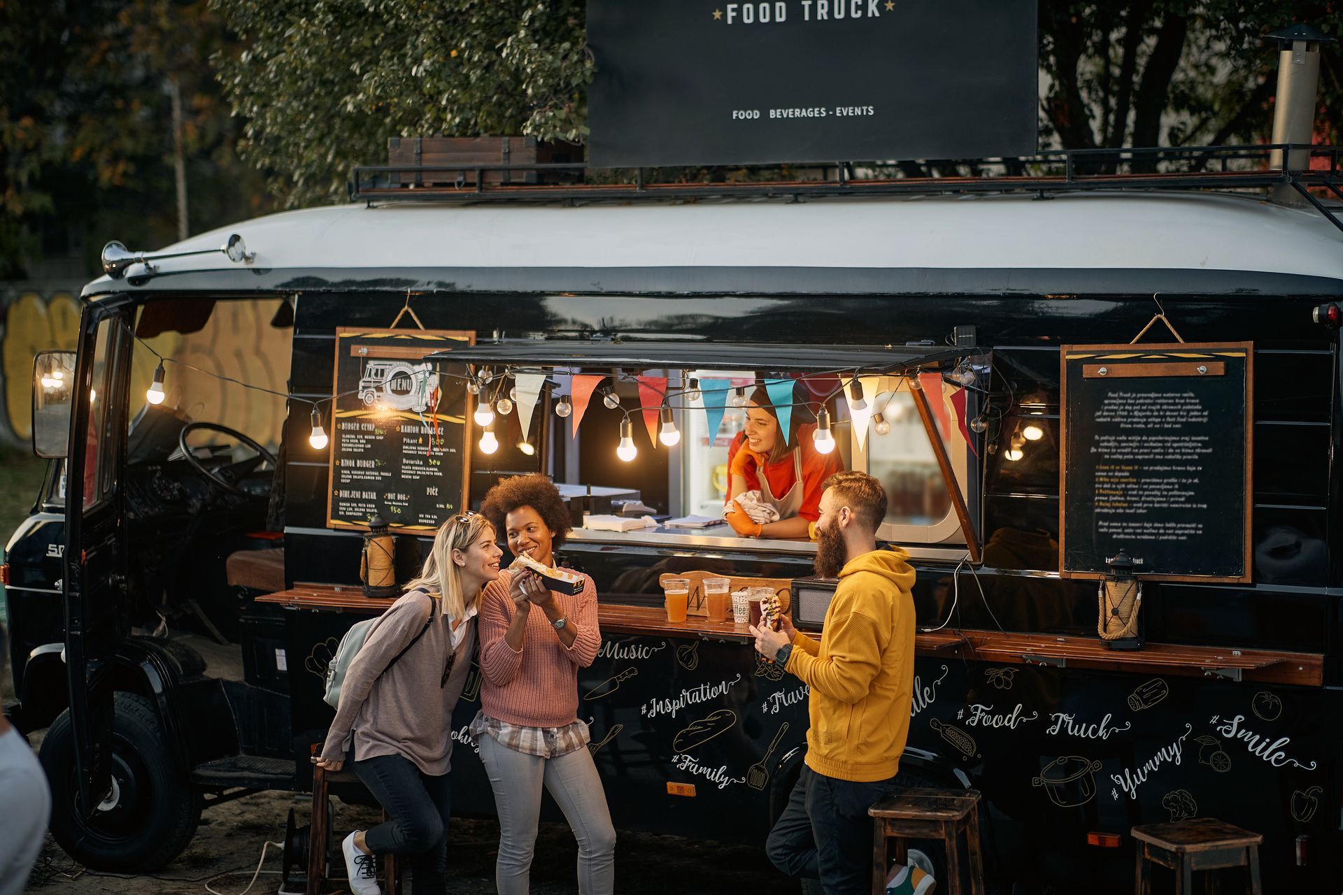 A group of people are eating food from a food truck.