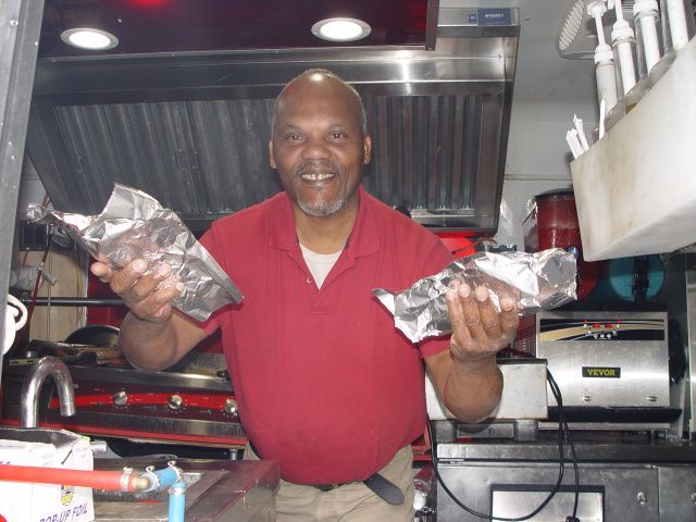 A man in a red shirt is holding a piece of aluminum foil