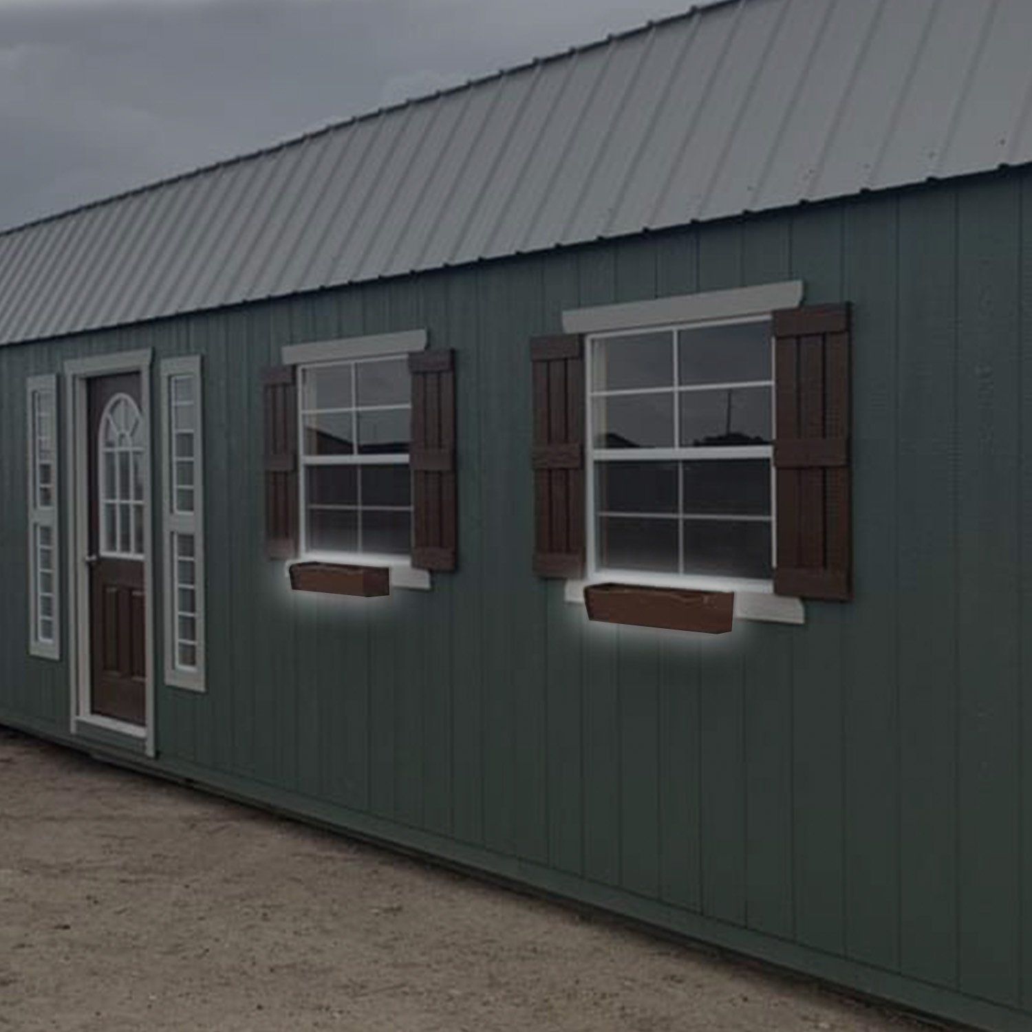 A green house with brown shutters on the windows
