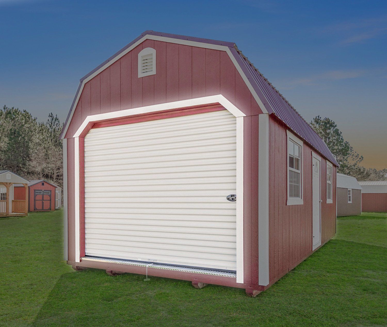 A red barn with a white garage door is in the middle of a grassy field.