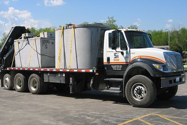 A white and black truck with the letter s on the side is parked in a parking lot